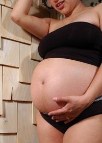 Беременная стоя мастурбирует писю и гладит руками большие груди
